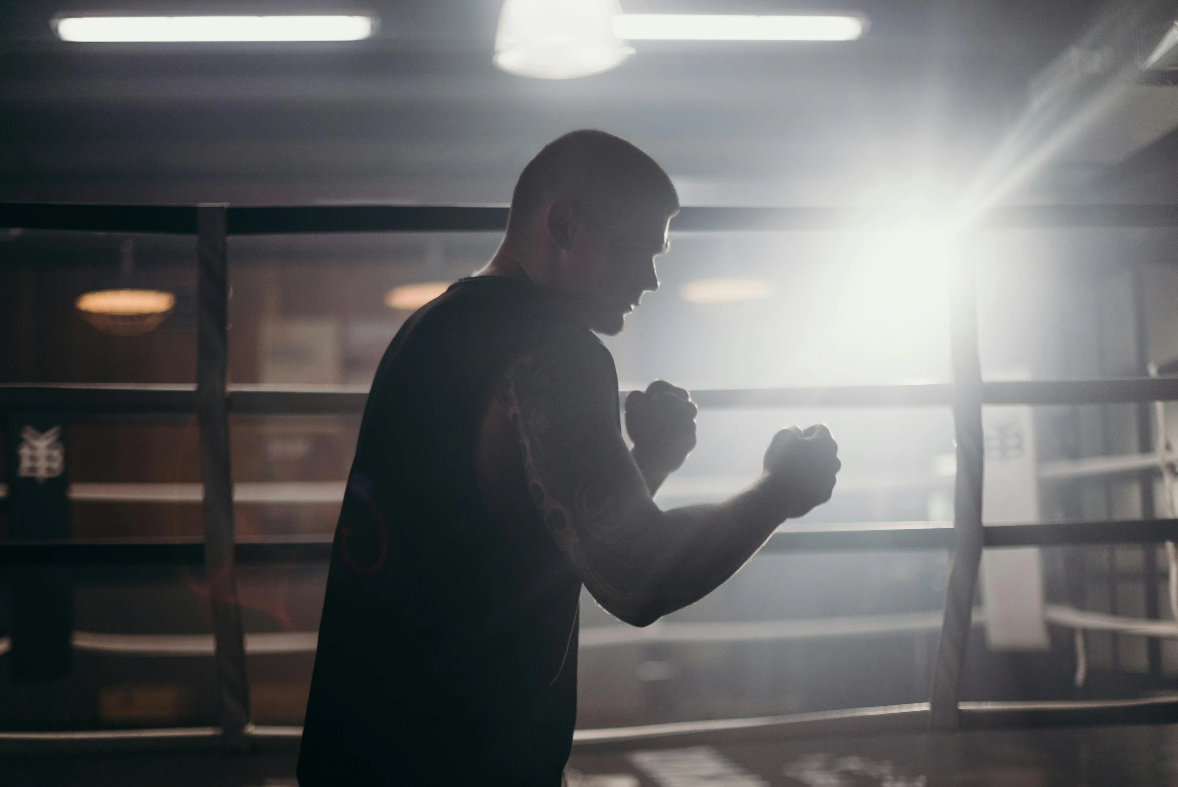 a man standing in the middle of a boxing ring, pexels contest winner, light and space, fist training, profile image, worksafe. cinematic, muscular bald man