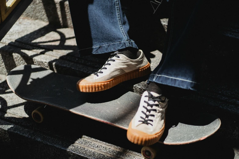 a person sitting on top of a skateboard, by Bernie D’Andrea, trending on pexels, rubber waffle outsole, cream, caramel. rugged, outlive streetwear collection