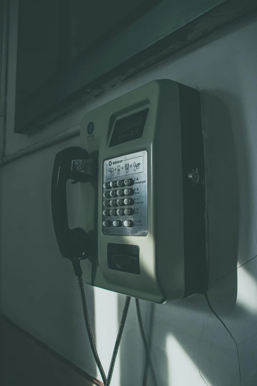 a close up of a telephone on a wall, inspired by Elsa Bleda, unsplash, grainy movie still, elevator, computer, dingy