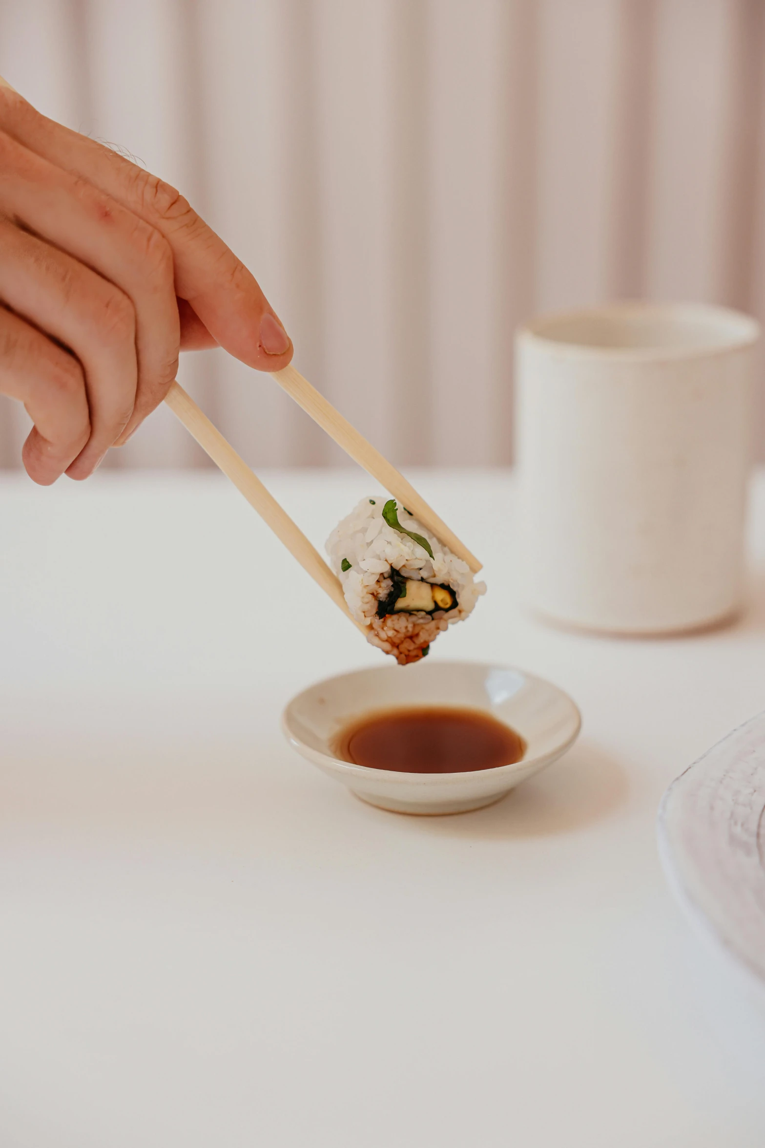 a person holding chopsticks over a plate of food, detailed product image, ginko showing a new mushi, melbourne, on a white table