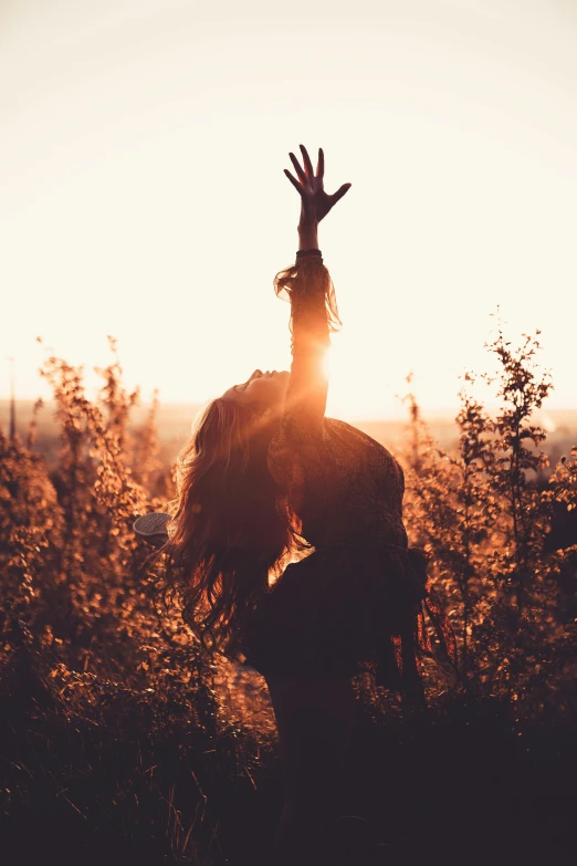 a person standing in a field with their hands in the air, flowing backlit hair, instagram picture, sassy pose, uncropped