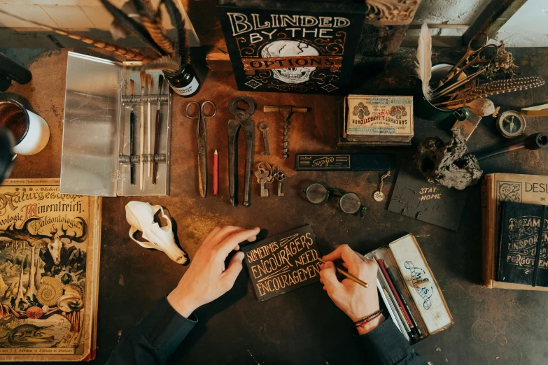 a person sitting at a table with a book, a woodcut, pexels contest winner, scrap metal on workbenches, estrange calligraphy, blind, thumbnail