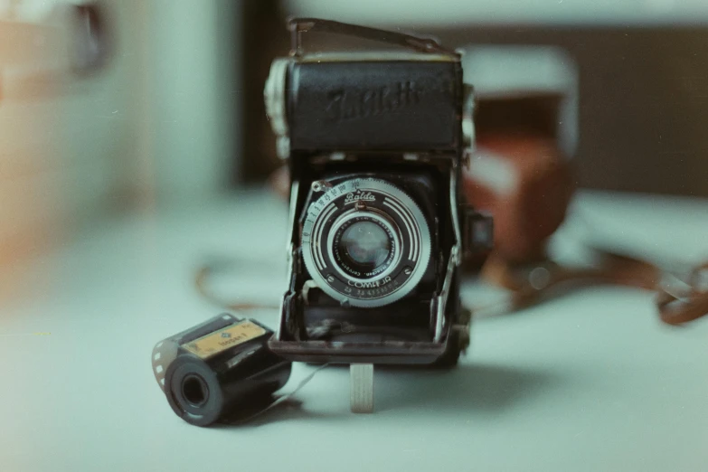 an old camera sitting on top of a table, pexels contest winner, photorealism, medium format color photography, snapshot, grainy, cute photograph