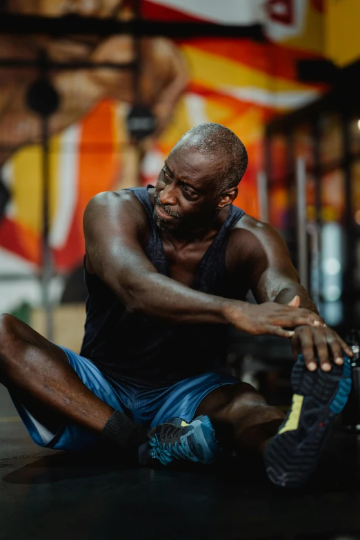 a man sitting on the ground in a gym, pexels contest winner, hyperrealism, lance reddick, sweating intensely, promo image, pixeled stretching