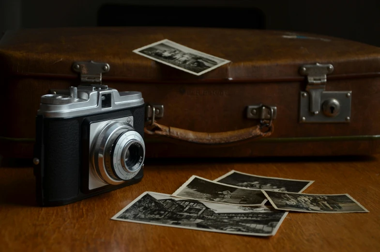 a camera sitting on top of a wooden table, inspired by Henri Cartier-Bresson, pexels contest winner, in suitcase, 1930s photograph, medium - format print, flash photograph