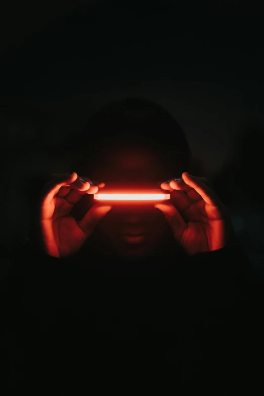 a person holding a red light in front of their face, a picture, by Adam Marczyński, afrofuturism, infinity mirror, profile pic, glowing tubes, shades