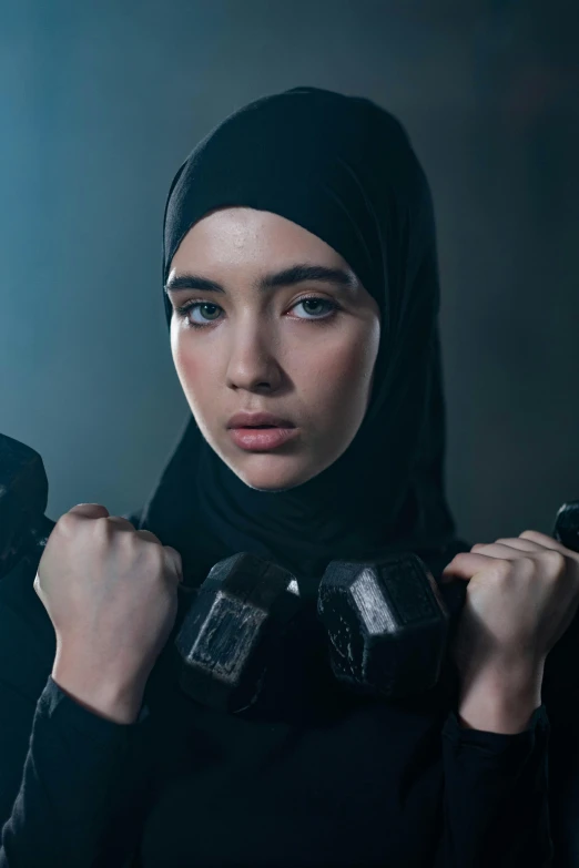 a woman in a black hijab poses for a picture, a colorized photo, trending on pexels, hurufiyya, lifting weights, lily collins, asian women, dystopian sci-fi character