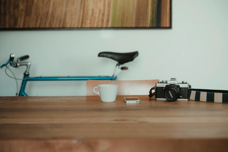 a camera sitting on top of a wooden table next to a coffee cup, trending on unsplash, minimalism, low quality photo, no people 4k, couch desk, medium format