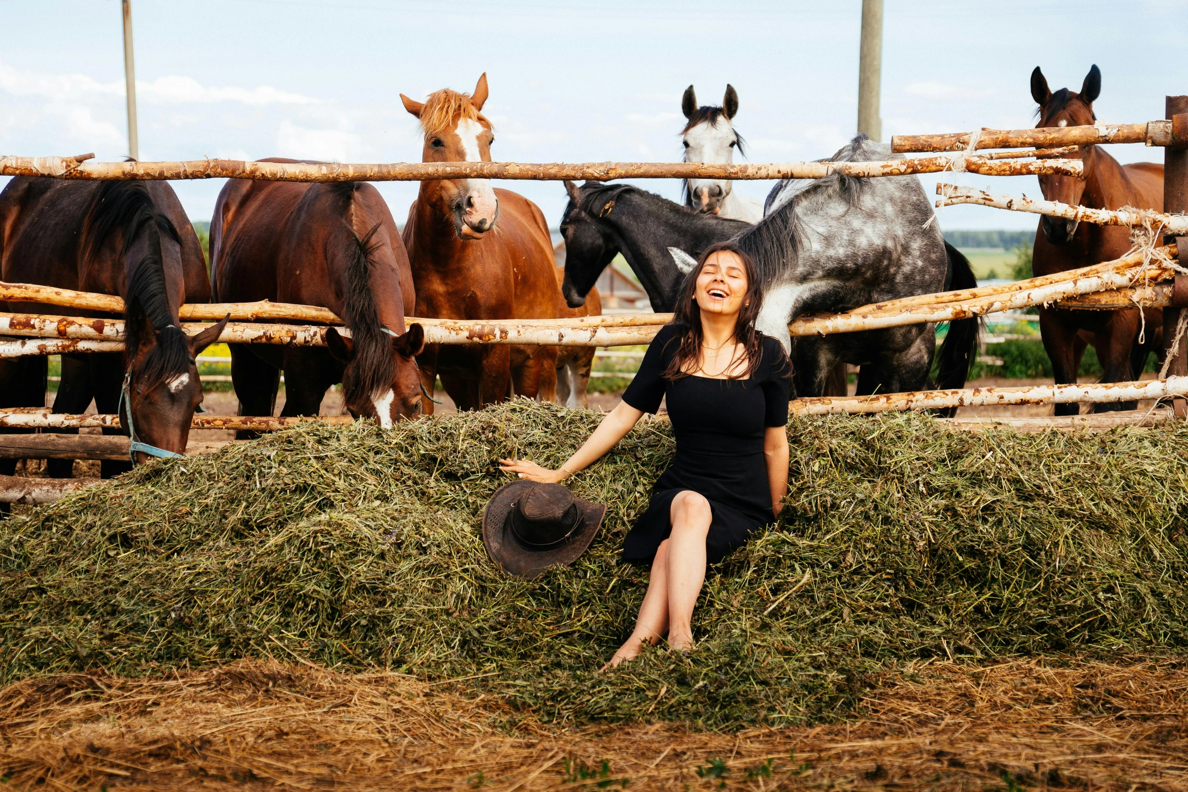 a woman sitting on top of a pile of hay next to horses, a portrait, by Julia Pishtar, pexels contest winner, mai anh tran, with a cool pose, 15081959 21121991 01012000 4k, promotional image