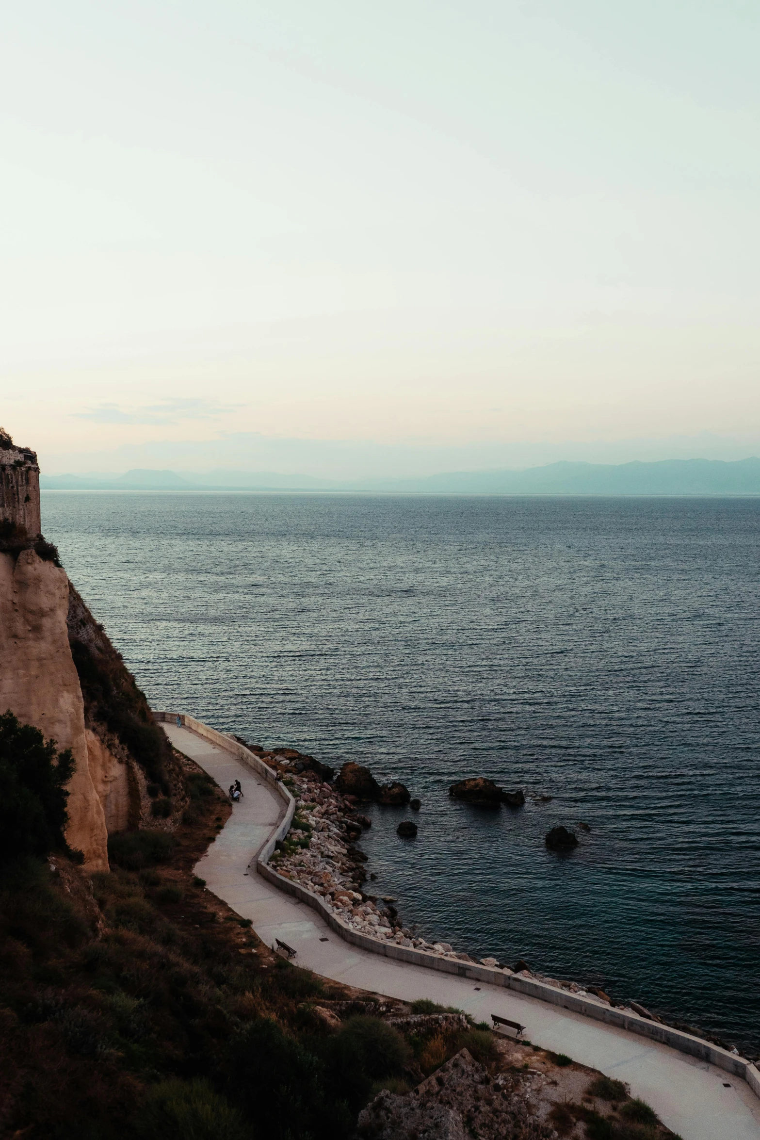 a lighthouse sitting on top of a cliff next to the ocean, by Alexis Grimou, low quality photo, greek, road to the sea, byzantine ruins