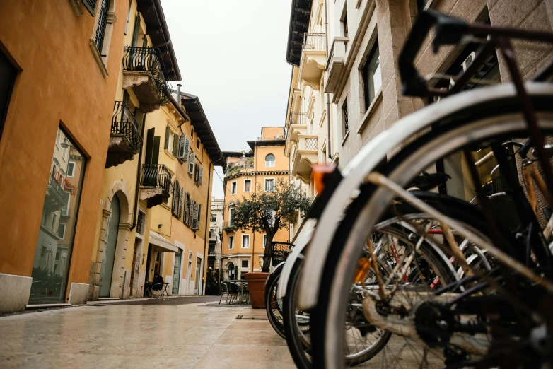 a couple of bikes parked on the side of a street, by Alessandro Galli Bibiena, pexels contest winner, renaissance, town square, seen from outside, profile image, ground view shot