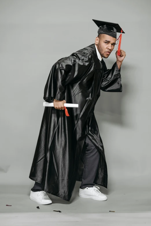 a man in a graduation gown holding a diploma, an album cover, by Joe Stefanelli, fighting stance, for gq, handsome hip hop young black man, holding a trident