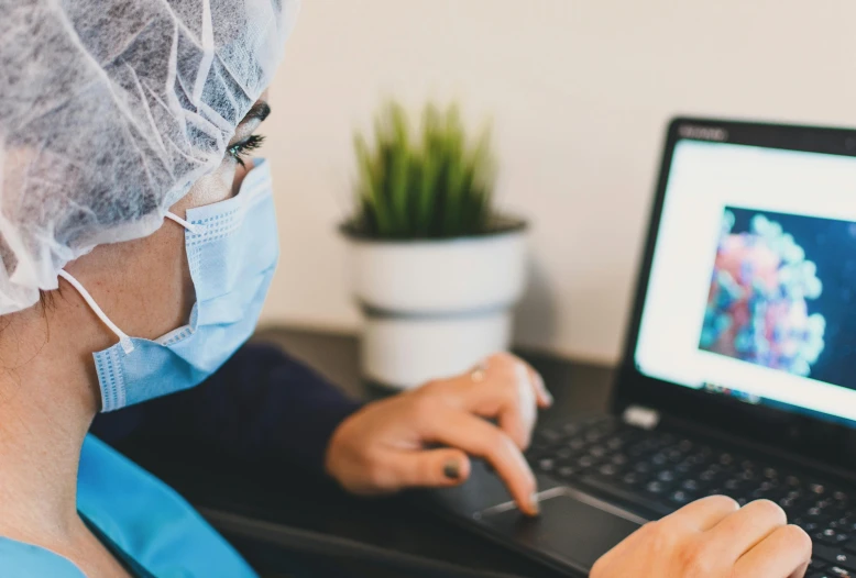 a woman in a surgical mask working on a laptop, by Meredith Dillman, trending on pexels, hurufiyya, male physician, close up to the screen, worksafe. instagram photo, paul davey