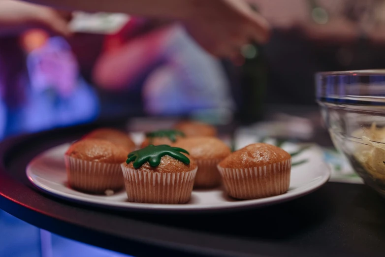 a close up of a plate of cupcakes on a table, by Julia Pishtar, unsplash, nightlife, profile image, jets, fan favorite