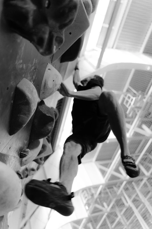 a black and white photo of a man on a climbing wall, central hub, monochrome:-2, sport, black & white