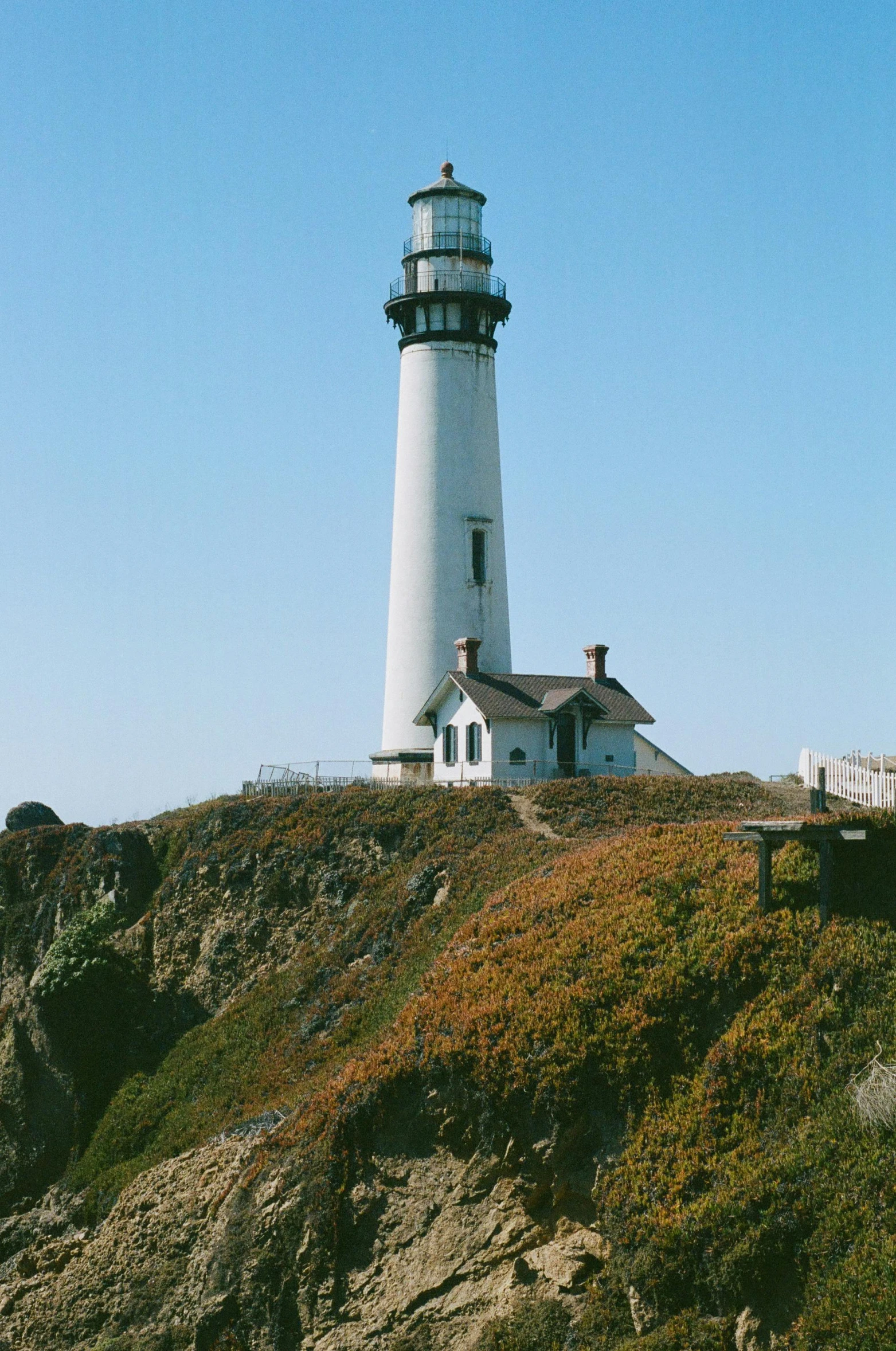 a white lighthouse sitting on top of a cliff, bay area, chimneys, ignant, exterior