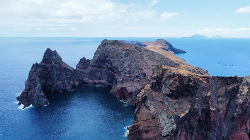 a large rock formation in the middle of the ocean, by Daniel Lieske, pexels contest winner, sharp cliffs, vale encantado, two medium sized islands, piroca