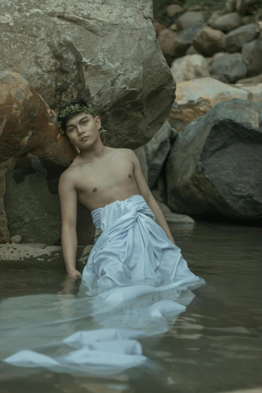 a man that is standing in some water, an album cover, inspired by I Ketut Soki, unsplash, sumatraism, non binary model, wearing toga, canyon, classic realism