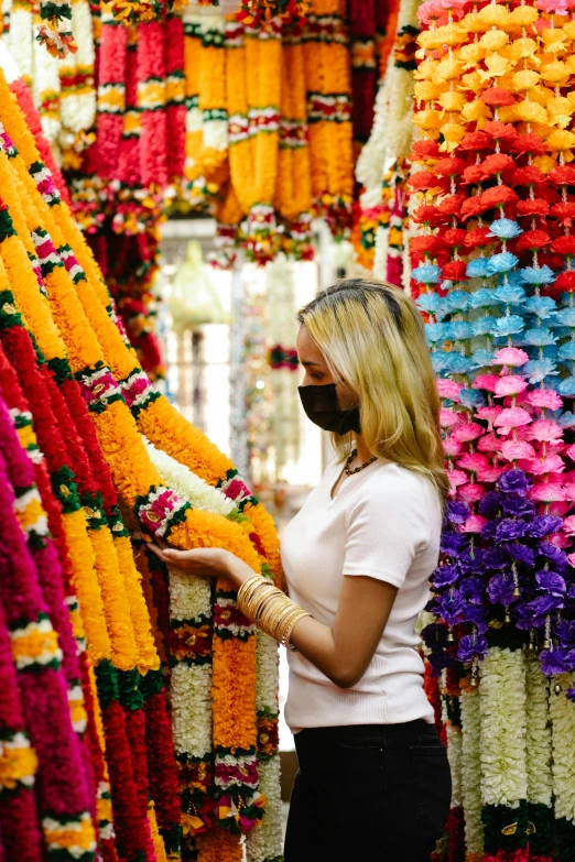 a woman standing in front of a bunch of flowers, hindu ornaments, facemask made of flowers, inspect in inventory image, hanging