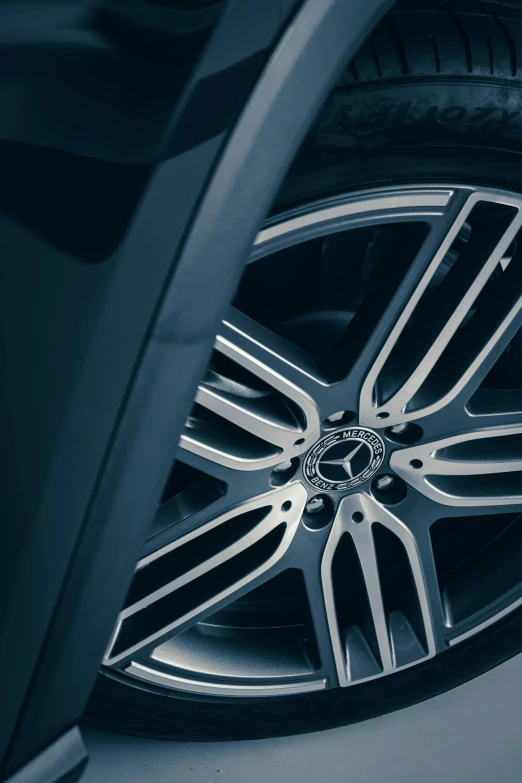 a close up of a tire on a car, desaturated blue, gun metal grey, mercedez benz, multi-part