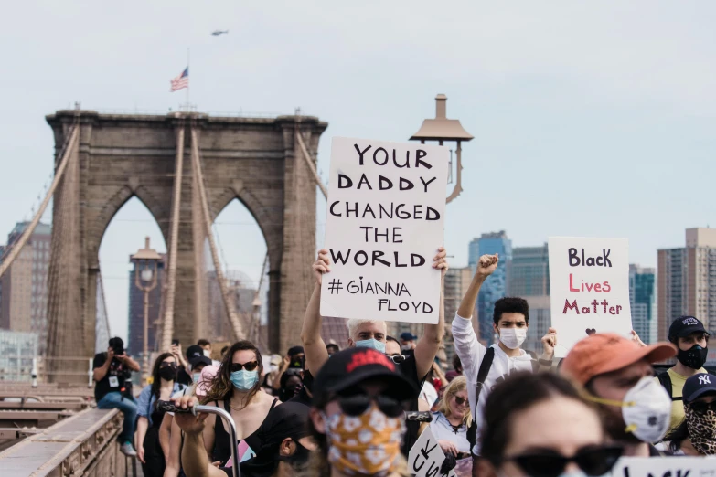 a group of people walking across a bridge holding signs, by Olivia Peguero, trending on pexels, cover of new york times, panel of black, handwritten, a person standing in front of a