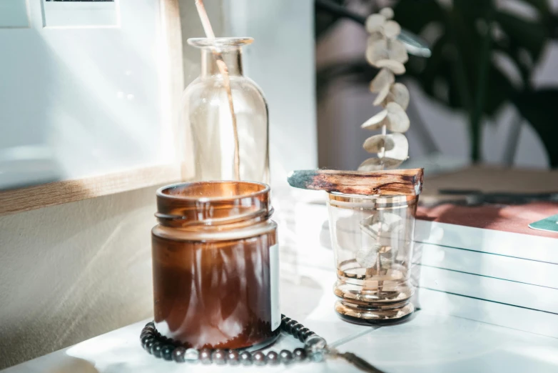 a couple of jars sitting on top of a table, a still life, trending on pexels, brown, pouring, skincare, morning detail