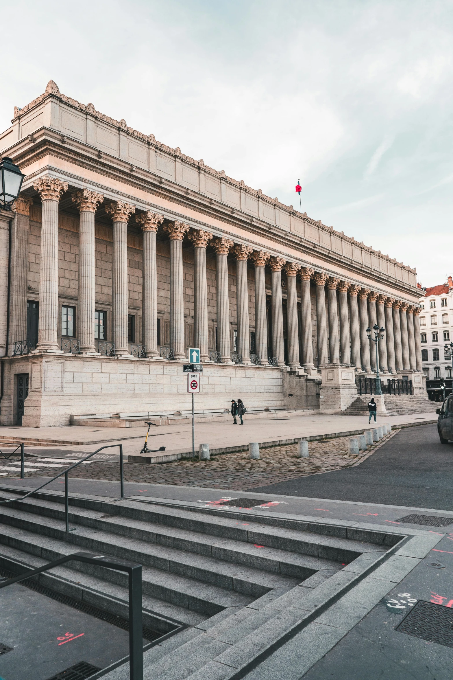 a large building sitting on the side of a road, a marble sculpture, paris school, columns, 🚿🗝📝