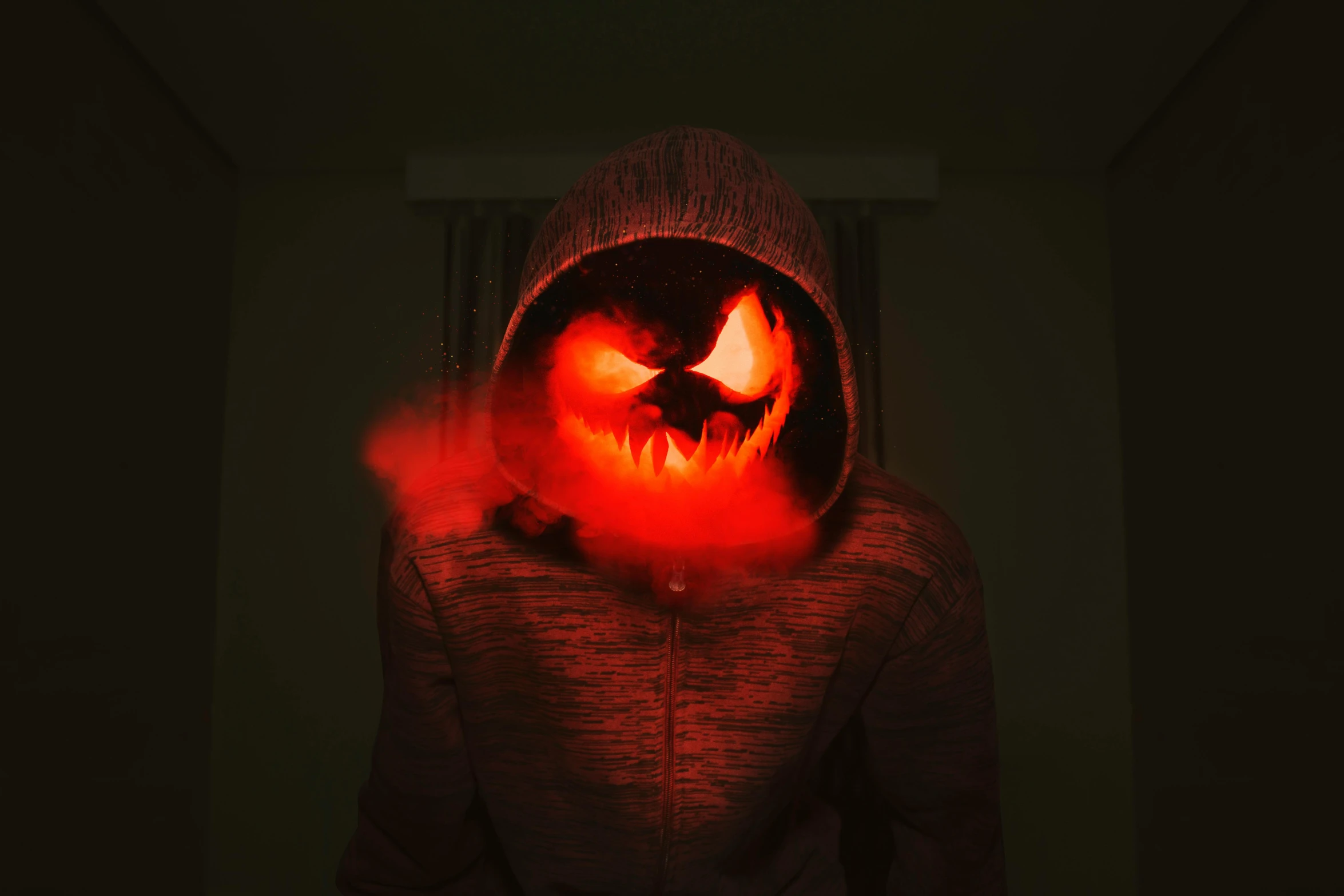 a person in a hoodie with a glowing face, inspired by Steven James Petruccio, pexels contest winner, pumpkin head, with red haze, mouth of hell, instagram picture