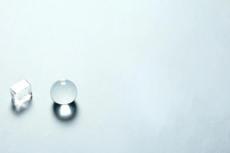 a couple of pieces of glass sitting on top of a table, inspired by Vija Celmins, unsplash, minimalism, the glass bead game, marble!! (eos 5ds r, white: 0.5, aluminum