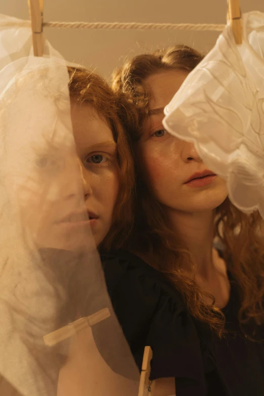 a couple of women standing next to each other, an album cover, inspired by Nan Goldin, renaissance, white transparent veil, visible pupils, goldilocks, ( ( theatrical ) )