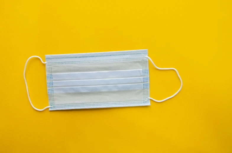 a medical mask on a yellow background, by Carey Morris, pexels, white muzzle and underside, square, blue and yellow color theme, rectangle