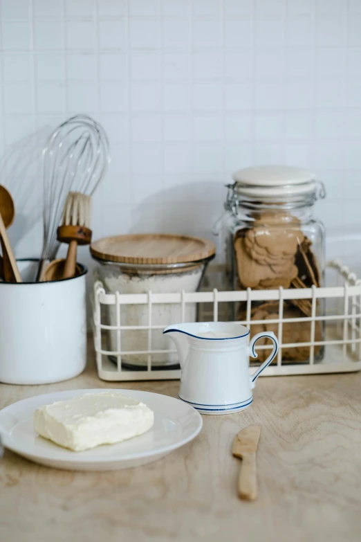 a close up of a plate of food on a counter, a still life, by Andries Stock, unsplash, jar on a shelf, butter, metal kitchen utensils, with a white background