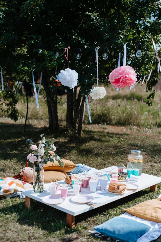 a picnic set up in the middle of a field, paper decoration, props containing trees, bubbly scenery, hanging