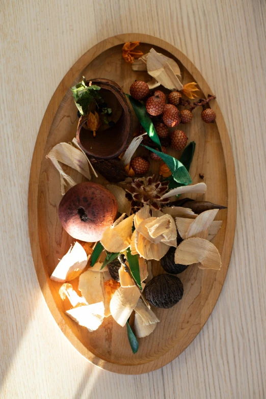 a close up of a plate of food on a table, a still life, inspired by Elsa Beskow, process art, wood materials, dead fruits, spices, brown