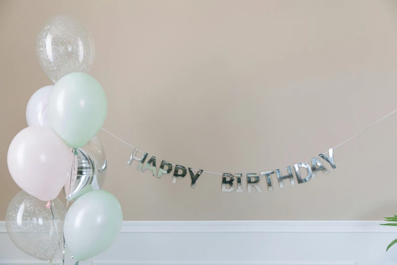 a bunch of balloons sitting on top of a table, a picture, full product shot, made out of shiny white metal, flowing lettering, pastel green