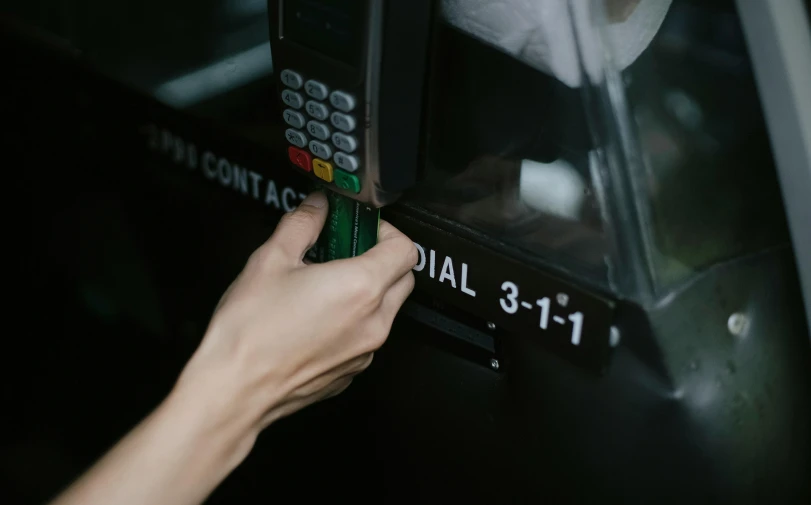 a close up of a person using an atm machine, by Emma Andijewska, pexels contest winner, cybertruck, a telephone receiver in hand, rule of three, hidden message