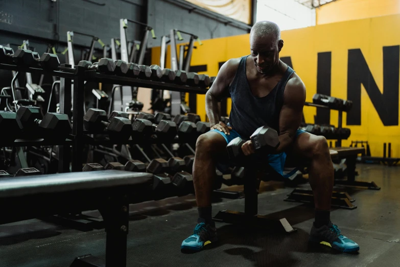 a man squatting on a bench in a gym, pexels contest winner, fan favorite, shot from cinematic, muscular bald man, lachlan bailey