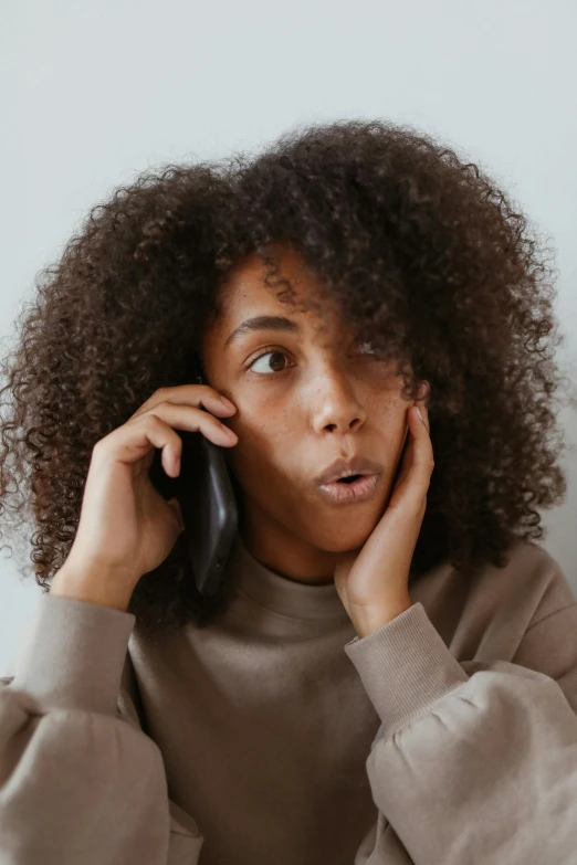 a woman sitting at a table talking on a cell phone, trending on pexels, renaissance, frizzy hair, surprised, with brown skin, flat ironed hair