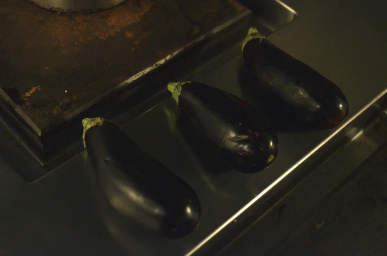 a group of eggplant sitting on top of a stove, taken with sony alpha 9, cinematic footage, digital image, 3 4 5 3 1