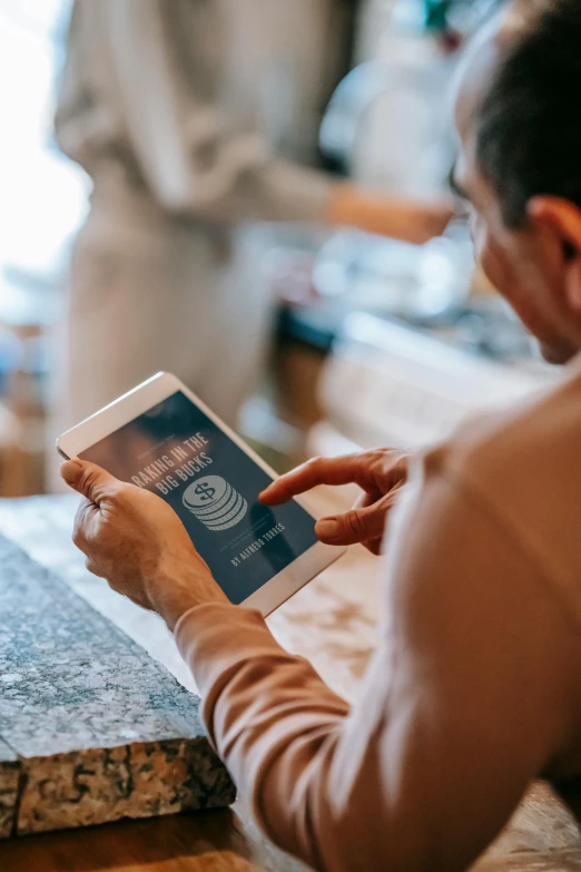 a woman sitting at a table using a tablet computer, a hologram, pexels contest winner, samsung smartthings, at checkout, gold, corporate phone app icon