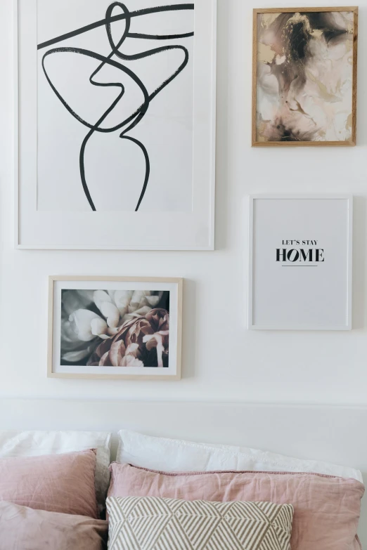 a bed room with a neatly made bed and pictures on the wall, poster art, by Dulah Marie Evans, trending on unsplash, visual art, white petal, white marble interior photograph, in white lettering, framed art