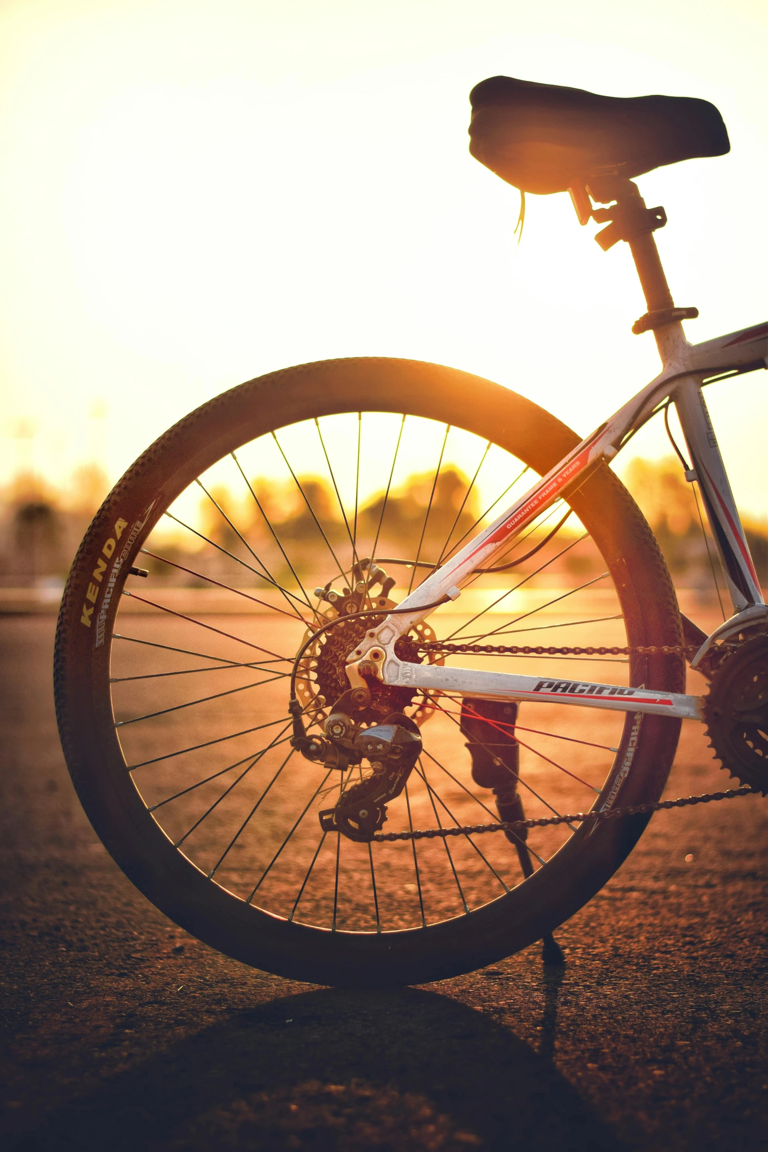 a bicycle parked on the side of the road, during a sunset, up close, tournament, cogs and wheels