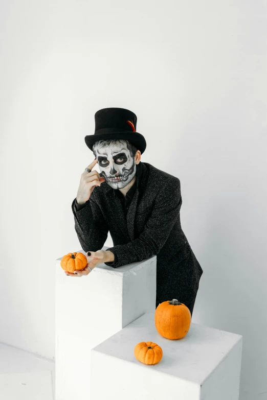 a man dressed as a skeleton poses for a picture, by artist, pexels, on a white table, a suited man in a hat, black and orange, a handsome