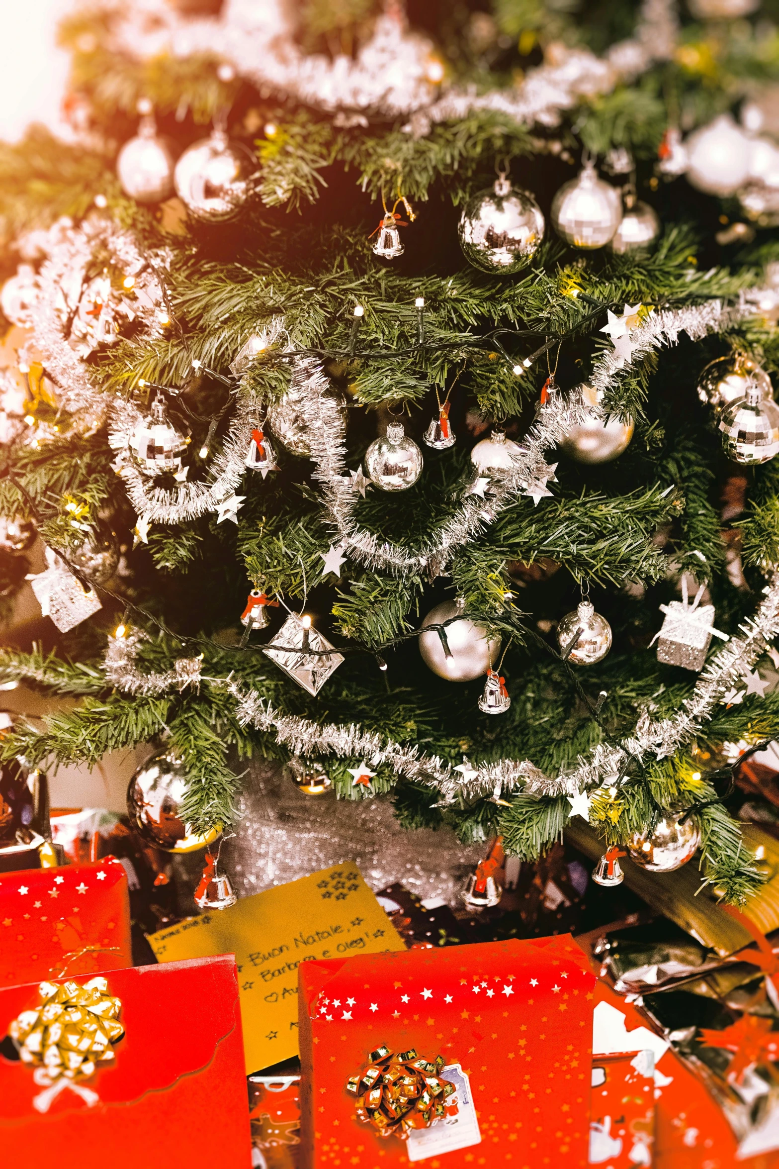 a christmas tree sitting next to a pile of presents, silver ornaments, close up shot from the top, tree's, multiple stories