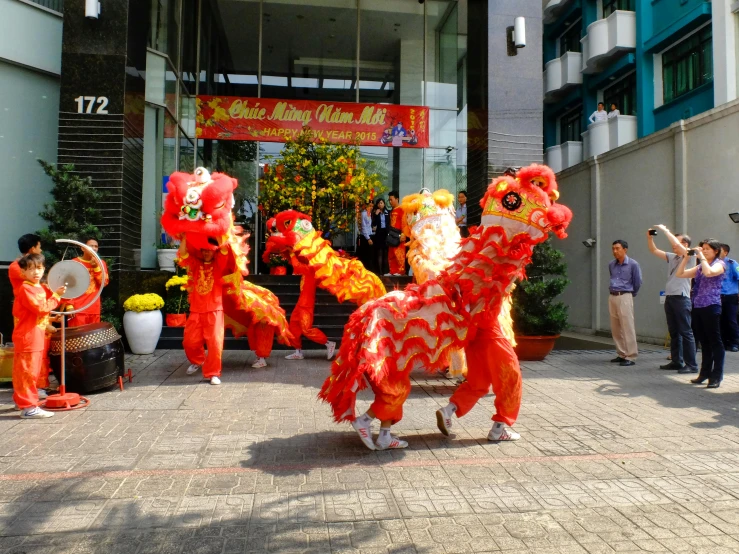 a group of people standing in front of a building, inspired by Pu Hua, pexels contest winner, tai costume, lions, vietnam, square