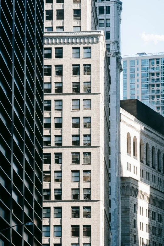 a city street filled with lots of tall buildings, inspired by Thomas Struth, trending on unsplash, modernism, chiseled architecture, 1910s architecture, close-up shot from behind, wall street