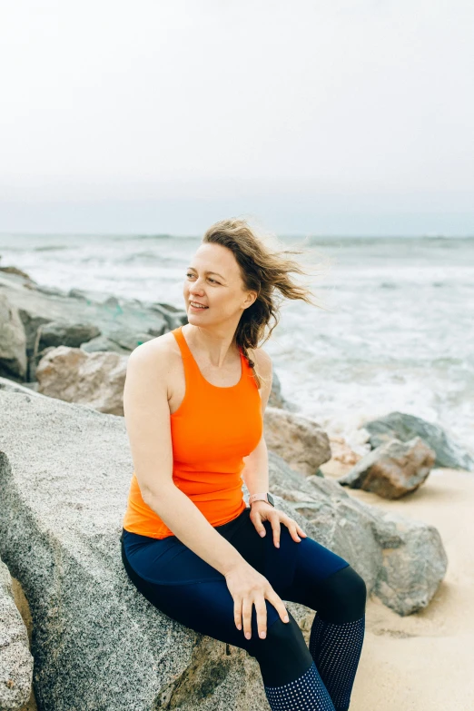 a woman sitting on a rock on the beach, a portrait, unsplash, happening, yoga, plain background, aged 4 0, profile image