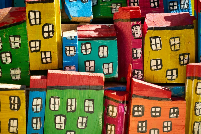 a pile of colorful painted houses sitting on top of each other, by Lee Loughridge, pexels contest winner, folk art, wood art, textured, brightly lit, rectangle