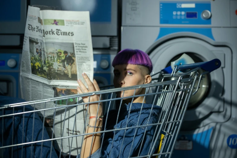 a woman sitting in a shopping cart reading a newspaper, a portrait, pexels contest winner, private press, cyberpunk dyed haircut, in a laundry mat, fashion shoot 8k, teletubbies in the backrooms