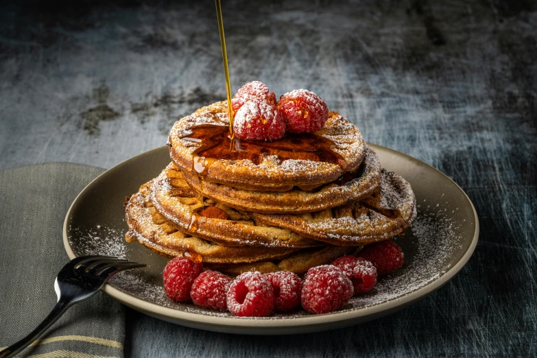 a plate topped with pancakes covered in powdered sugar and raspberries, inspired by Richmond Barthé, pexels contest winner, stroopwaffel, maple syrup sea, kek, high quality product image”